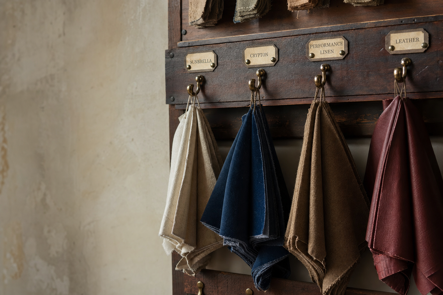 Workshop fabric sample wall with folded Sunbrella, Crypton, performance linen, and leather swatches on hooks
